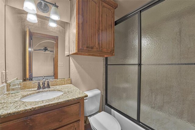 21698 SW Coombs Rd, Cache, OK 73527 - bathroom featuring vanity, toilet, combined bath / shower with glass door, and a textured wall