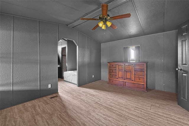 21698 SW Coombs Rd, Cache, OK 73527 - additional living space with ceiling fan, arched walkways, wood finished floors, lofted ceiling, and a decorative wall
