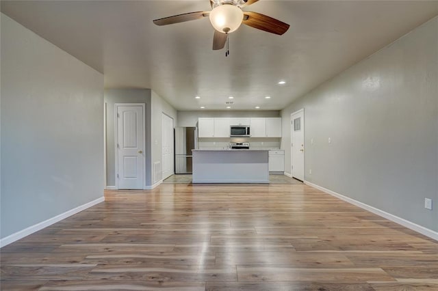 403 S Debra Ct Unit 401, Stillwater, OK 74074 - unfurnished living room with light wood-style flooring, baseboards, ceiling fan, and recessed lighting