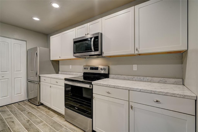 403 S Debra Ct Unit 401, Stillwater, OK 74074 - kitchen featuring appliances with stainless steel finishes, white cabinetry, recessed lighting, and light wood-style floors