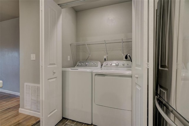 403 S Debra Ct Unit 401, Stillwater, OK 74074 - clothes washing area with wood finished floors, independent washer and dryer, and baseboards
