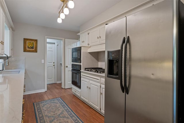 3804 NW 66th St, Oklahoma City, OK 73116 - kitchen with black appliances, white cabinetry, wood finished floors, baseboards, and a sink