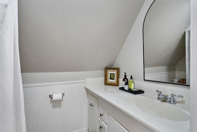 3804 NW 66th St, Oklahoma City, OK 73116 - bathroom featuring vaulted ceiling, vanity, a decorative wall, and wainscoting