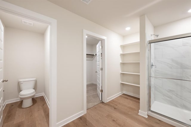 5515 Windstone Dr, Norman, OK 73072 - full bathroom with wood finished floors, a stall shower, toilet, a spacious closet, and recessed lighting