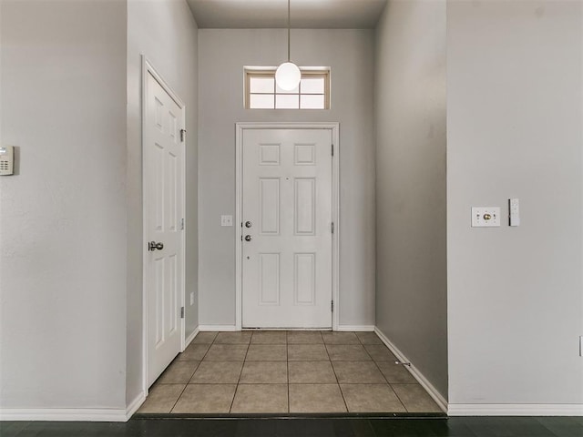 foyer featuring baseboards and tile patterned flooring