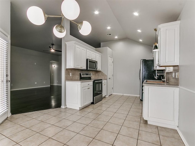 kitchen with appliances with stainless steel finishes, backsplash, light tile patterned floors, white cabinetry, and ceiling fan