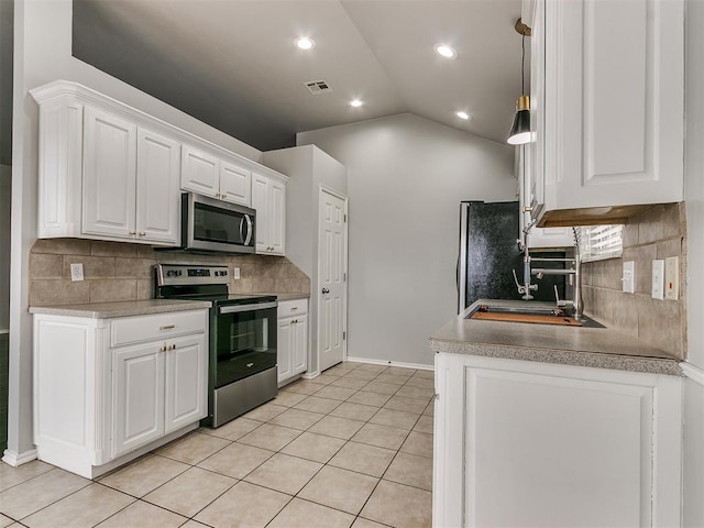 kitchen featuring appliances with stainless steel finishes, decorative backsplash, white cabinetry, vaulted ceiling, and recessed lighting