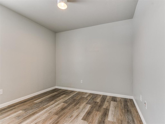 spare room featuring wood finished floors and baseboards