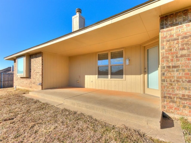 back of property with a patio area, brick siding, and fence