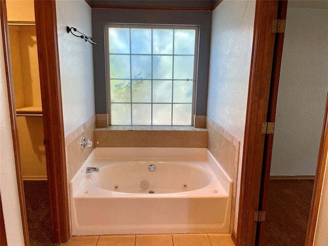 3113 SW 125th St, Oklahoma City, OK 73170 - bathroom featuring a tub with jets, tile patterned flooring, and a textured wall