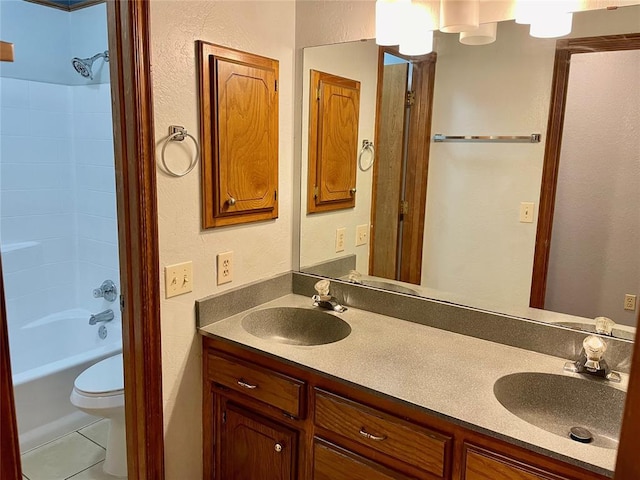 3113 SW 125th St, Oklahoma City, OK 73170 - full bathroom with double vanity, a textured wall, toilet, washtub / shower combination, and tile patterned floors