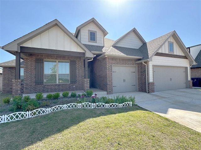 view of front facade featuring an attached garage, brick siding, a front yard, a shingled roof, and driveway