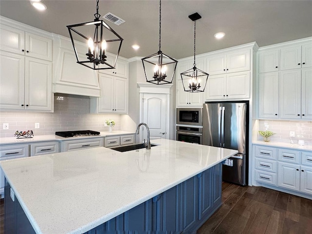 kitchen with a sink, a chandelier, stainless steel appliances, dark wood finished floors, and recessed lighting