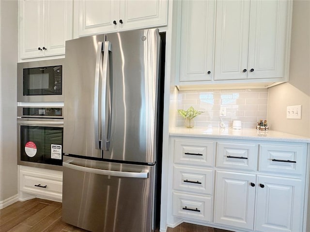 kitchen featuring stainless steel appliances, dark wood-type flooring, tasteful backsplash, and white cabinets