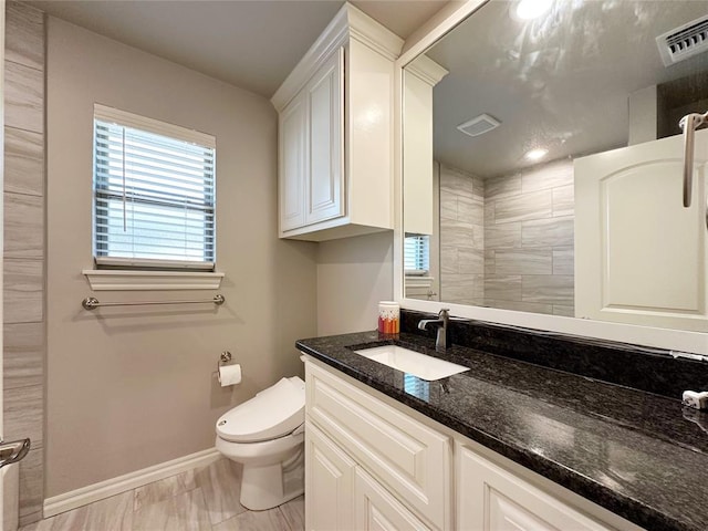 full bathroom with baseboards, vanity, toilet, and a shower