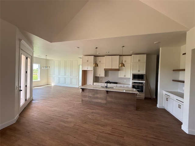 6921 Lake View Ct, Cashion, OK 73016 - kitchen with appliances with stainless steel finishes, dark wood-style floors, lofted ceiling, white cabinets, and a kitchen bar