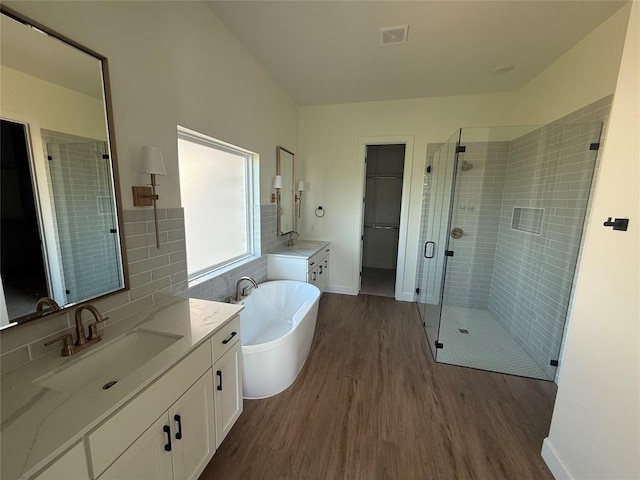 6921 Lake View Ct, Cashion, OK 73016 - full bath with wood finished floors, a shower stall, a soaking tub, two vanities, and a walk in closet