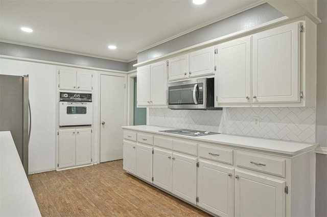 8720 Raven Ave, Oklahoma City, OK 73132 - kitchen with appliances with stainless steel finishes, white cabinets, light countertops, decorative backsplash, and light wood-type flooring