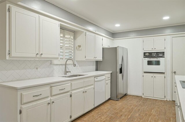 8720 Raven Ave, Oklahoma City, OK 73132 - kitchen featuring white appliances, a sink, light wood-type flooring, white cabinets, and light countertops