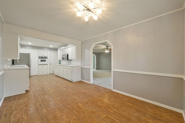 8720 Raven Ave, Oklahoma City, OK 73132 - kitchen featuring stainless steel appliances, arched walkways, light wood finished floors, ornamental molding, and baseboards