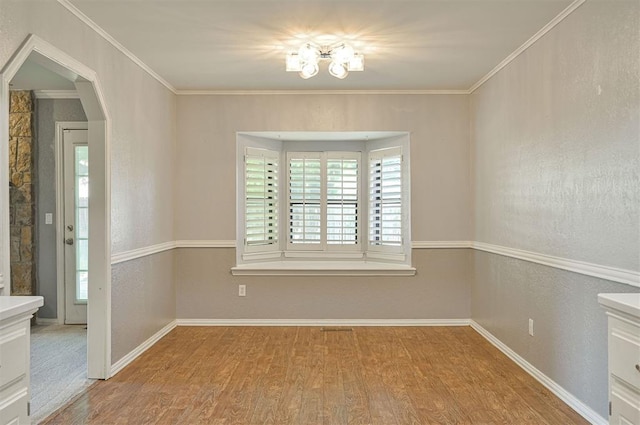 8720 Raven Ave, Oklahoma City, OK 73132 - empty room featuring plenty of natural light, wood finished floors, a chandelier, baseboards, and crown molding