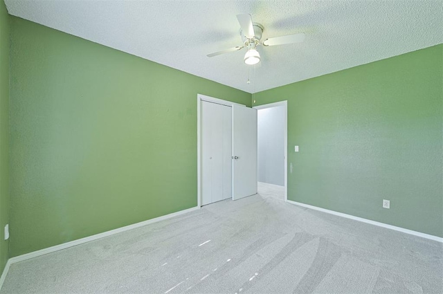 8720 Raven Ave, Oklahoma City, OK 73132 - unfurnished bedroom featuring carpet floors, a closet, ceiling fan, and a textured ceiling