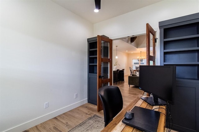 office space featuring light wood-style floors, a chandelier, and baseboards