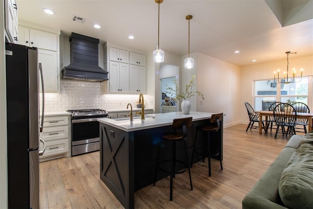 kitchen featuring appliances with stainless steel finishes, premium range hood, decorative backsplash, light wood-type flooring, and baseboards