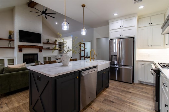 kitchen with stainless steel appliances, open floor plan, white cabinetry, beam ceiling, and recessed lighting