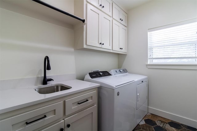 laundry room with cabinet space, independent washer and dryer, and baseboards
