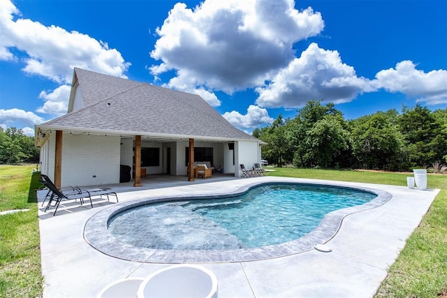 swimming pool with a patio and a yard