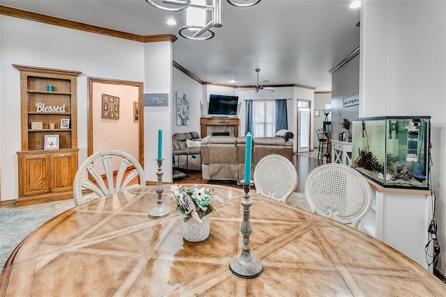 5608 Bent Creek Dr, Oklahoma City, OK 73135 - dining area featuring crown molding, a ceiling fan, a fireplace, and a chandelier