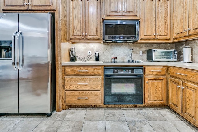 5608 Bent Creek Dr, Oklahoma City, OK 73135 - kitchen featuring black appliances, light countertops, tasteful backsplash, and brown cabinets
