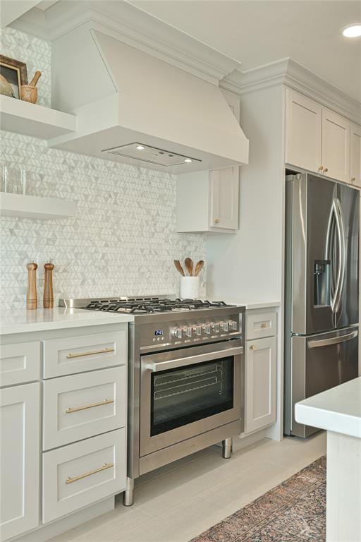 2650 NW 25th St, Oklahoma City, OK 73107 - kitchen featuring appliances with stainless steel finishes, premium range hood, light countertops, ornamental molding, and tasteful backsplash