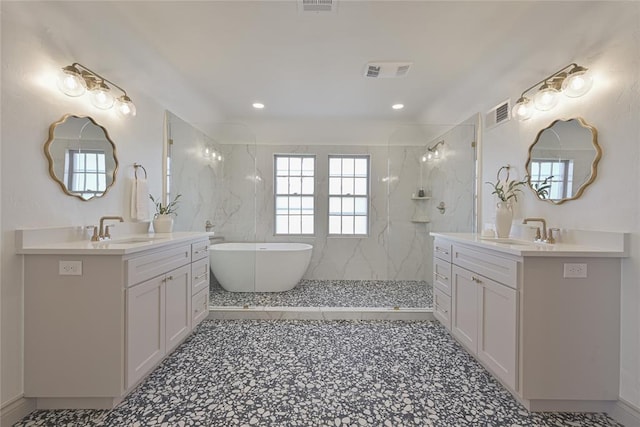 2650 NW 25th St, Oklahoma City, OK 73107 - full bath featuring plenty of natural light, walk in shower, two vanities, a freestanding bath, and recessed lighting