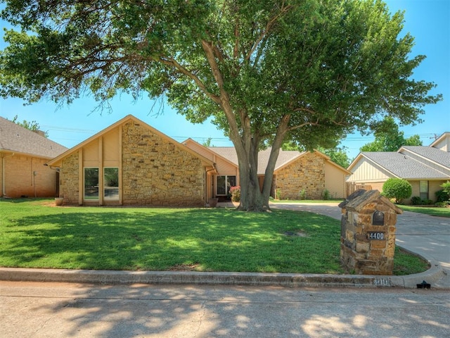 4400 Windsong Way, Oklahoma City, OK 73120 - mid-century home featuring stone siding, a front lawn, and curved driveway
