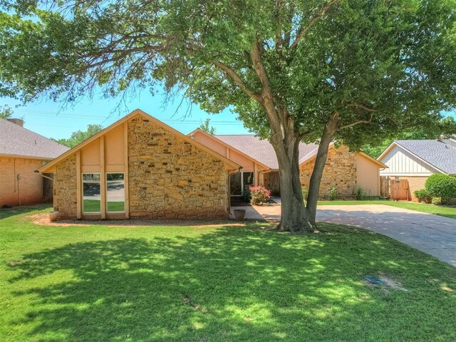 4400 Windsong Way, Oklahoma City, OK 73120 - view of front of house featuring stone siding, a front yard, and driveway