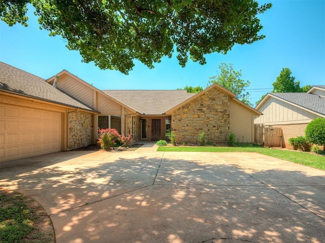 4400 Windsong Way, Oklahoma City, OK 73120 - view of front facade featuring stone siding, driveway, a garage, and roof with shingles