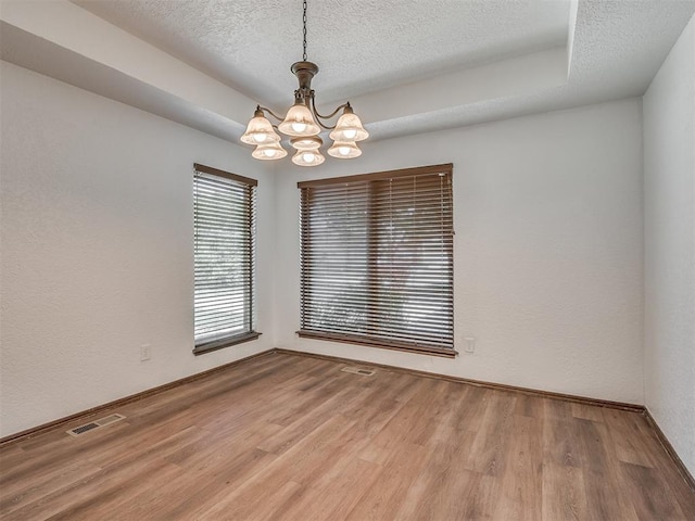4400 Windsong Way, Oklahoma City, OK 73120 - empty room featuring a chandelier, a textured ceiling, wood finished floors, and baseboards