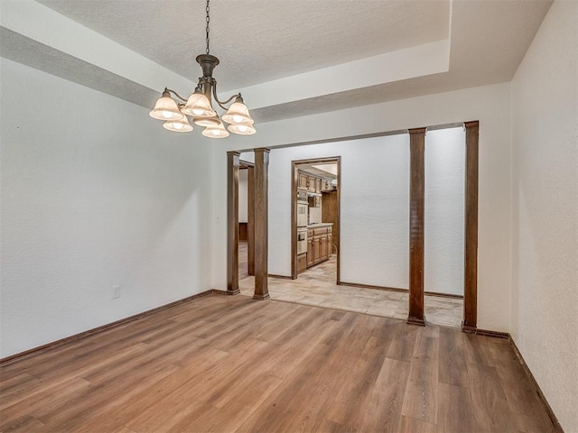 4400 Windsong Way, Oklahoma City, OK 73120 - unfurnished room featuring light wood finished floors, a chandelier, baseboards, and a textured ceiling