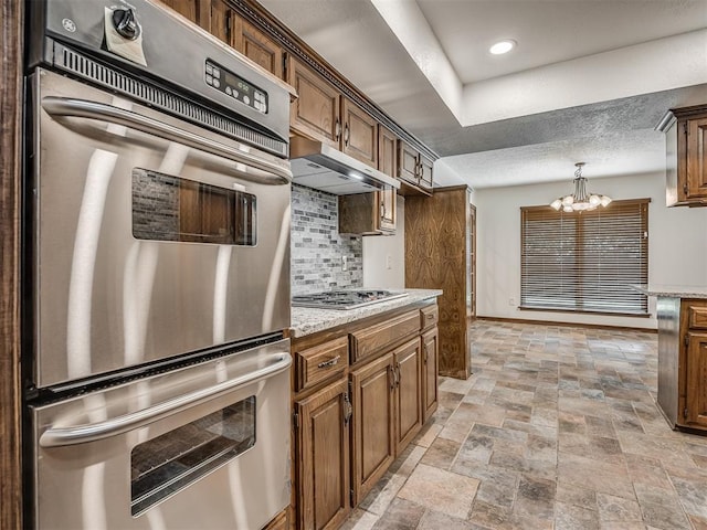 4400 Windsong Way, Oklahoma City, OK 73120 - kitchen featuring stainless steel appliances, a chandelier, ventilation hood, tasteful backsplash, and baseboards