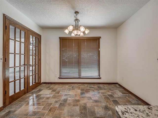 4400 Windsong Way, Oklahoma City, OK 73120 - unfurnished dining area featuring a chandelier, french doors, baseboards, healthy amount of natural light, and a textured ceiling