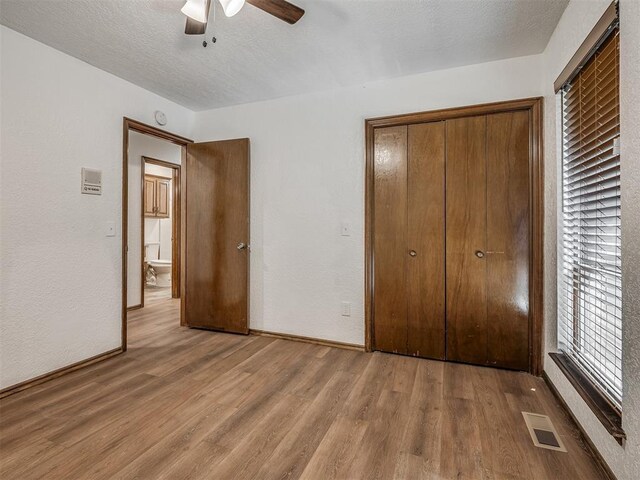4400 Windsong Way, Oklahoma City, OK 73120 - unfurnished bedroom featuring wood finished floors, a closet, a ceiling fan, a textured ceiling, and baseboards