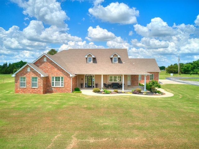 view of front of property featuring brick siding, a front lawn, and roof with shingles