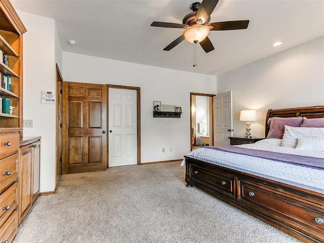 bedroom with light colored carpet, baseboards, and a ceiling fan