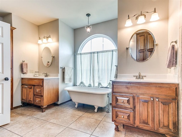 bathroom with two vanities, tile patterned floors, and a freestanding bath