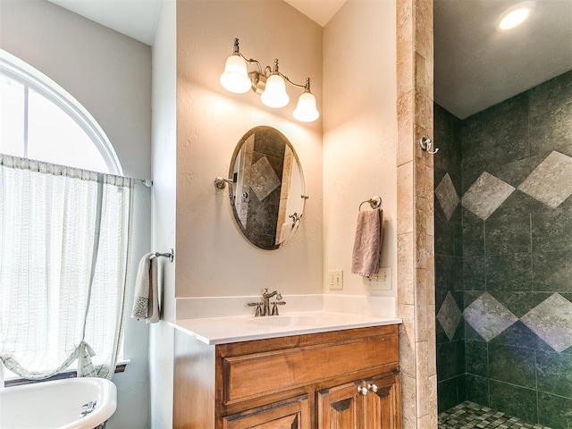 bathroom featuring tiled shower, vanity, and a freestanding bath