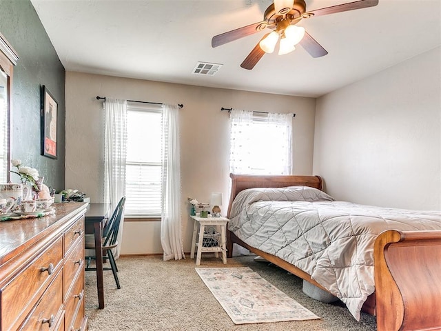 bedroom featuring light colored carpet, a ceiling fan, and baseboards