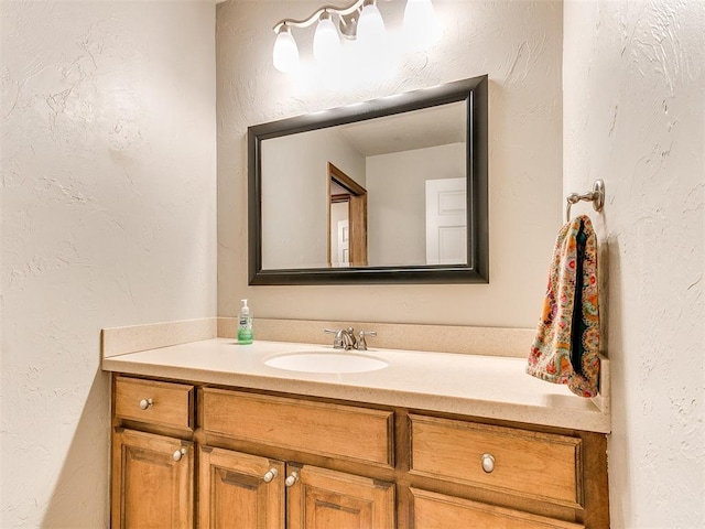 bathroom featuring vanity and a textured wall