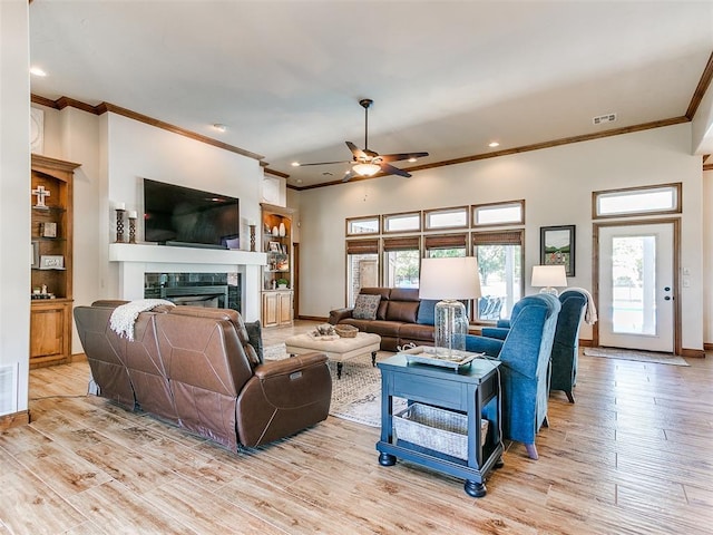 1486 County St Unit 2910 20, Acres Tuttle, OK 73089 - living room with crown molding, a ceiling fan, light wood finished floors, a tiled fireplace, and baseboards